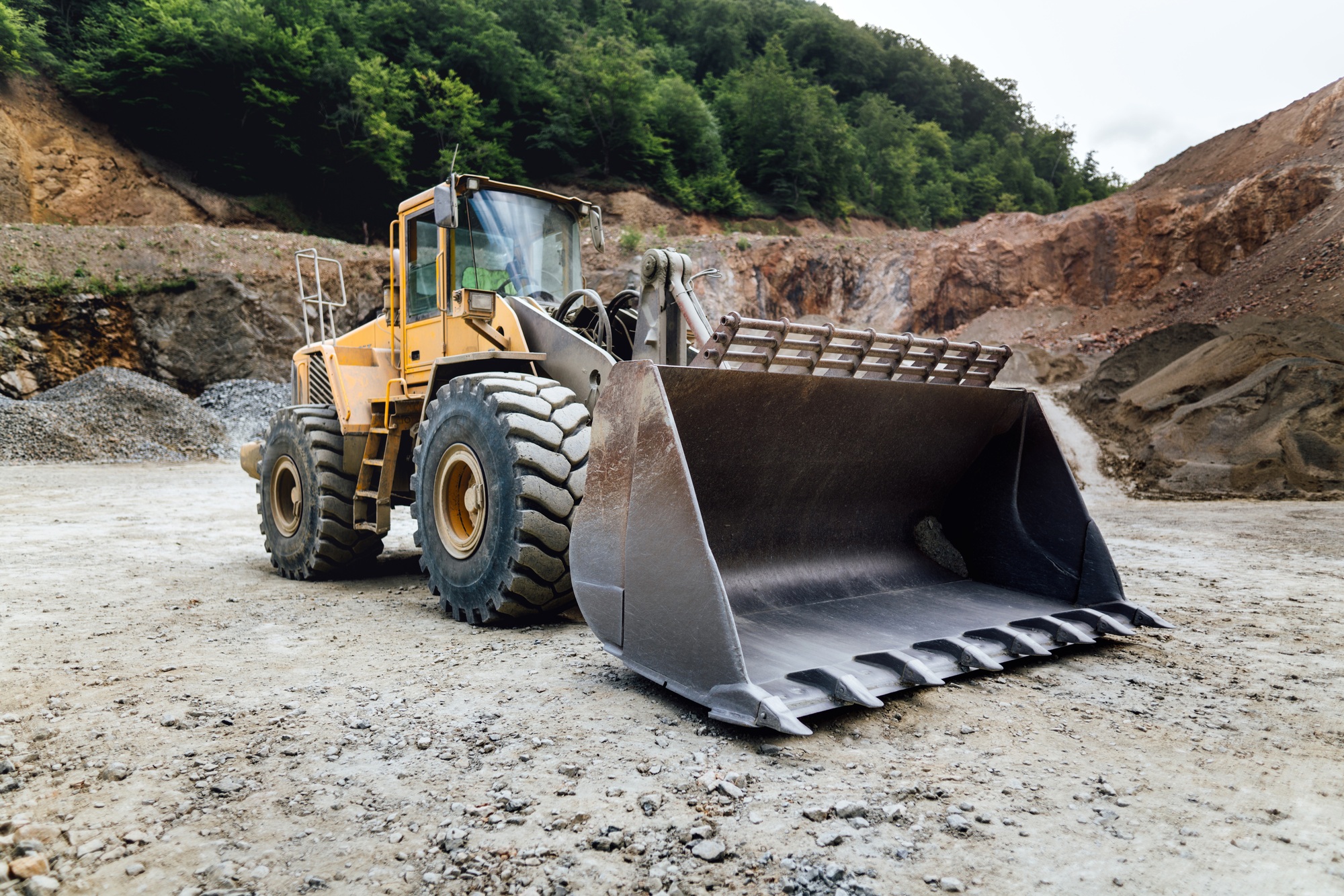 empty wheel loader machine loading gravel. Industrial machinery working at ore quarry